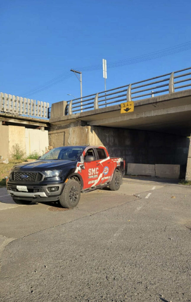 SMC Towing Group pickup truck parked near an underpass on a sunny day in Ottawa.